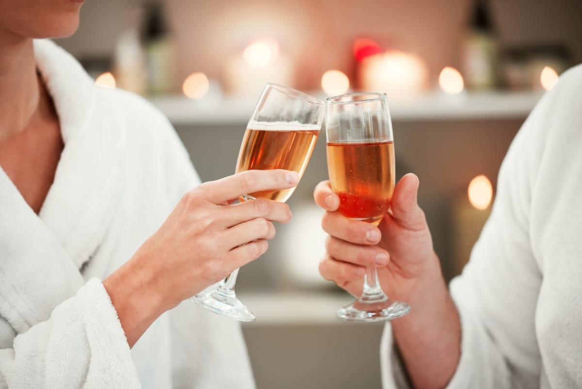 A couple enjoying a relaxing spa date while toasting with glasses of champagne.