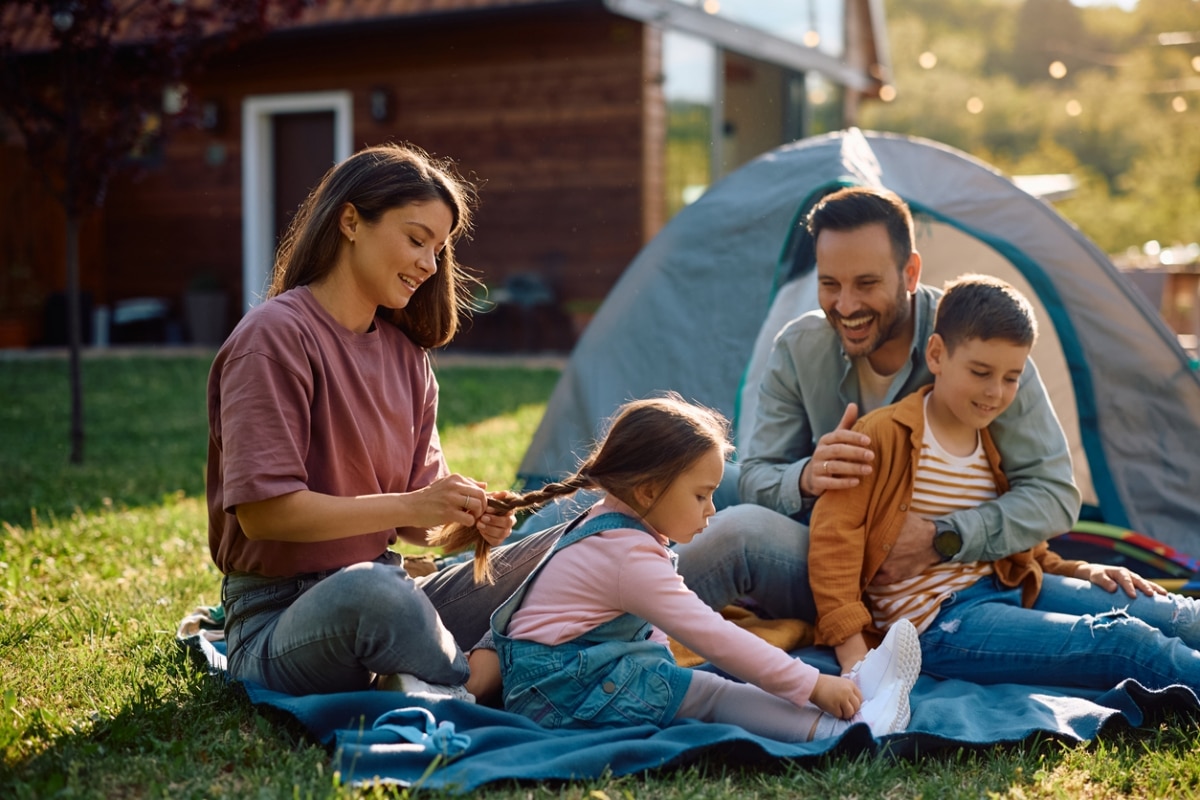 Happy parents enjoying with their kids while camping in their backyard.