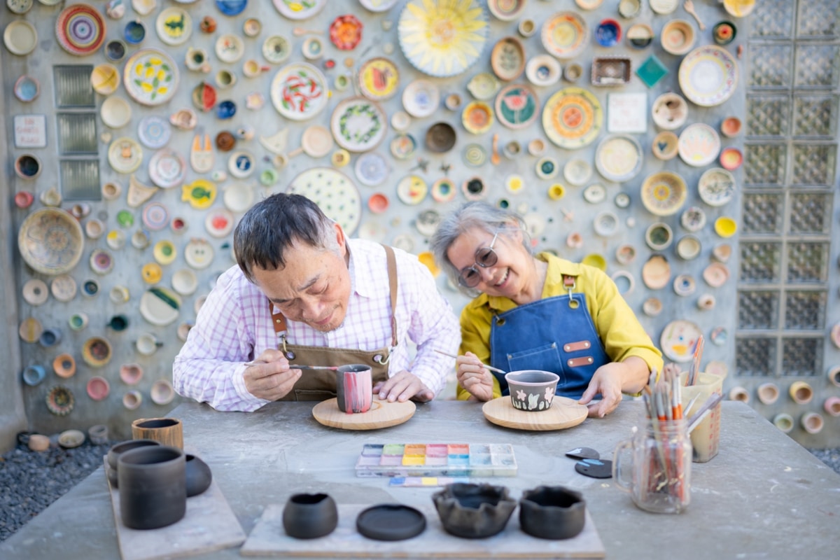 A happy Asian couple enjoying a pottery making class.